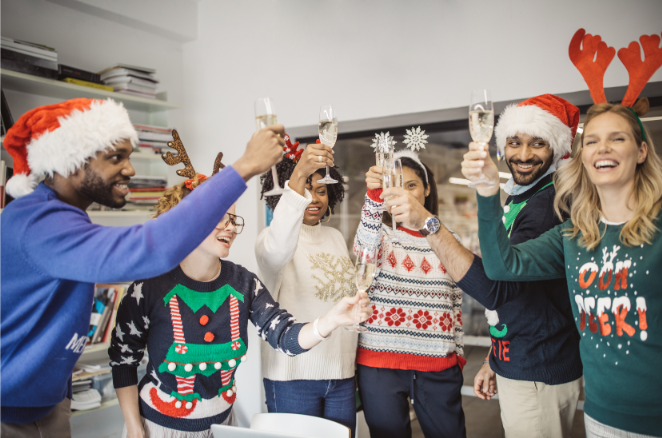 Groupe de collègues avec pulls de Noël qui trinquent